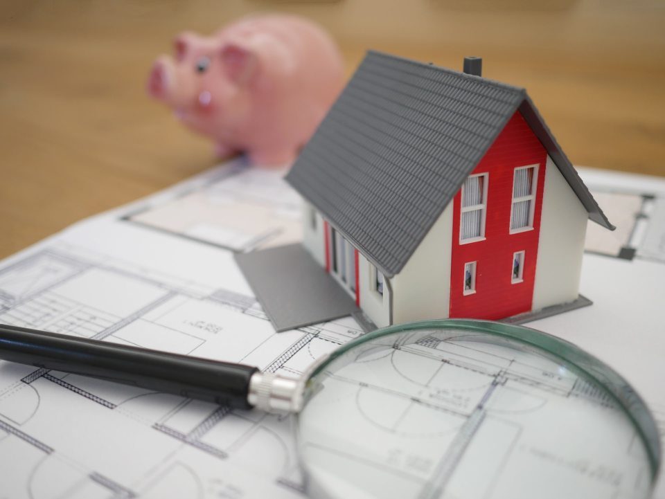 white and red wooden house beside grey-framed magnifying glass